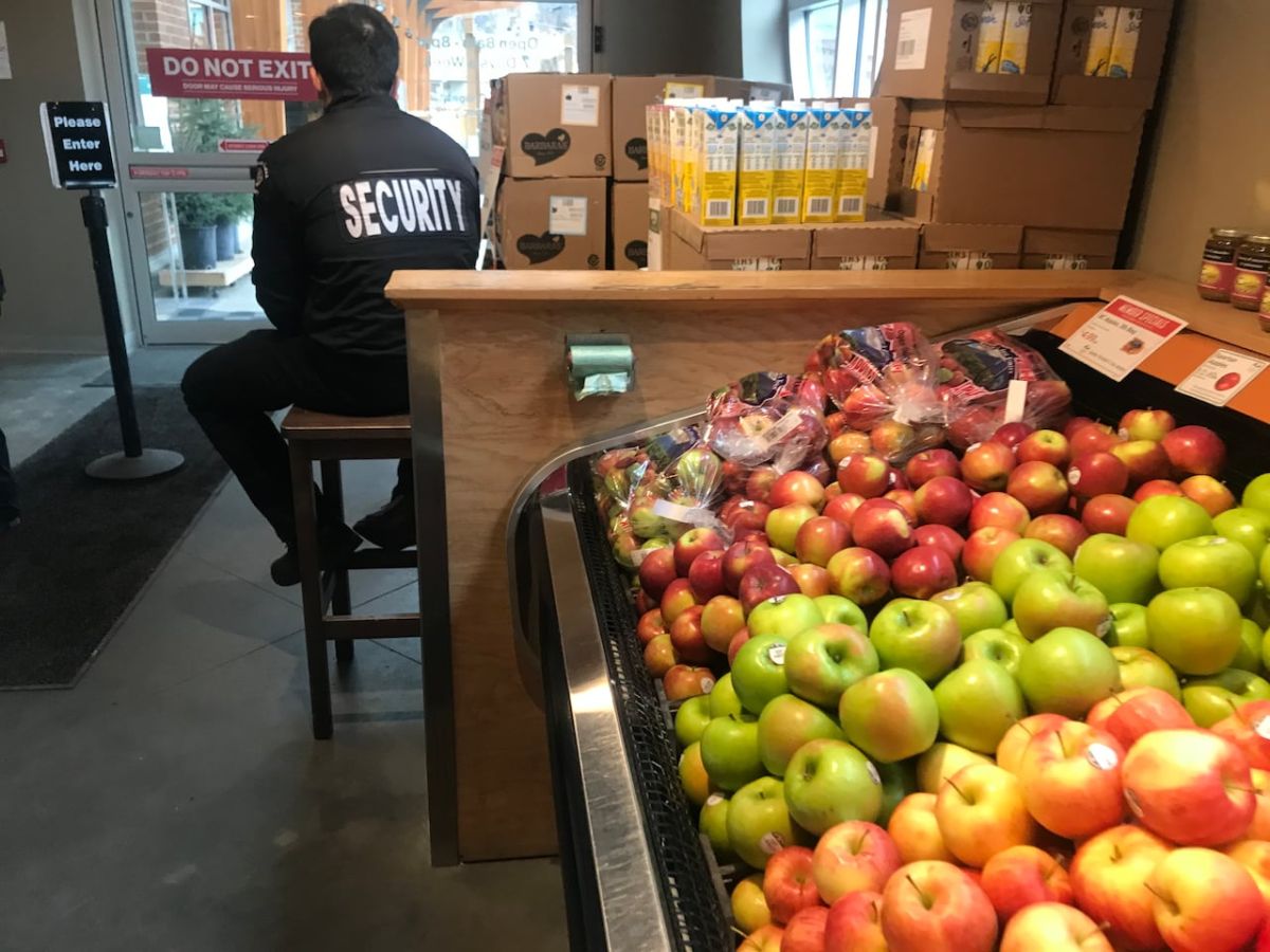 a-security-guard-sitting-at-the-entrance-of-kootenay-co-op-in-nelson-b-c