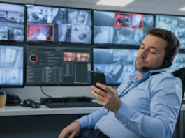 Maglovita budućnost CCTV operatera: AI neće ukinuti čoveka, ali će ugasiti lošu uslugu Nezainteresovani CCTV operater koristi mobilni telefon dok sistemi video-nadzora prikazuju aktivne alarme